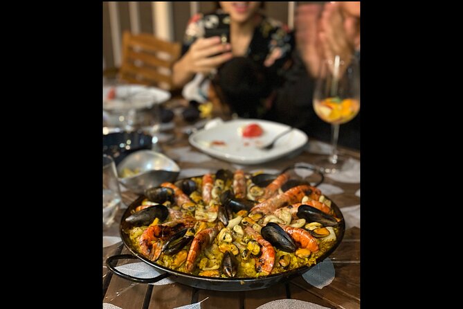 BBQ Paella in a Penthouse Terrace in Barcelona with a Chef - Cooking the Main: Stirring Seafood Paella Over Low Charcoal Heat